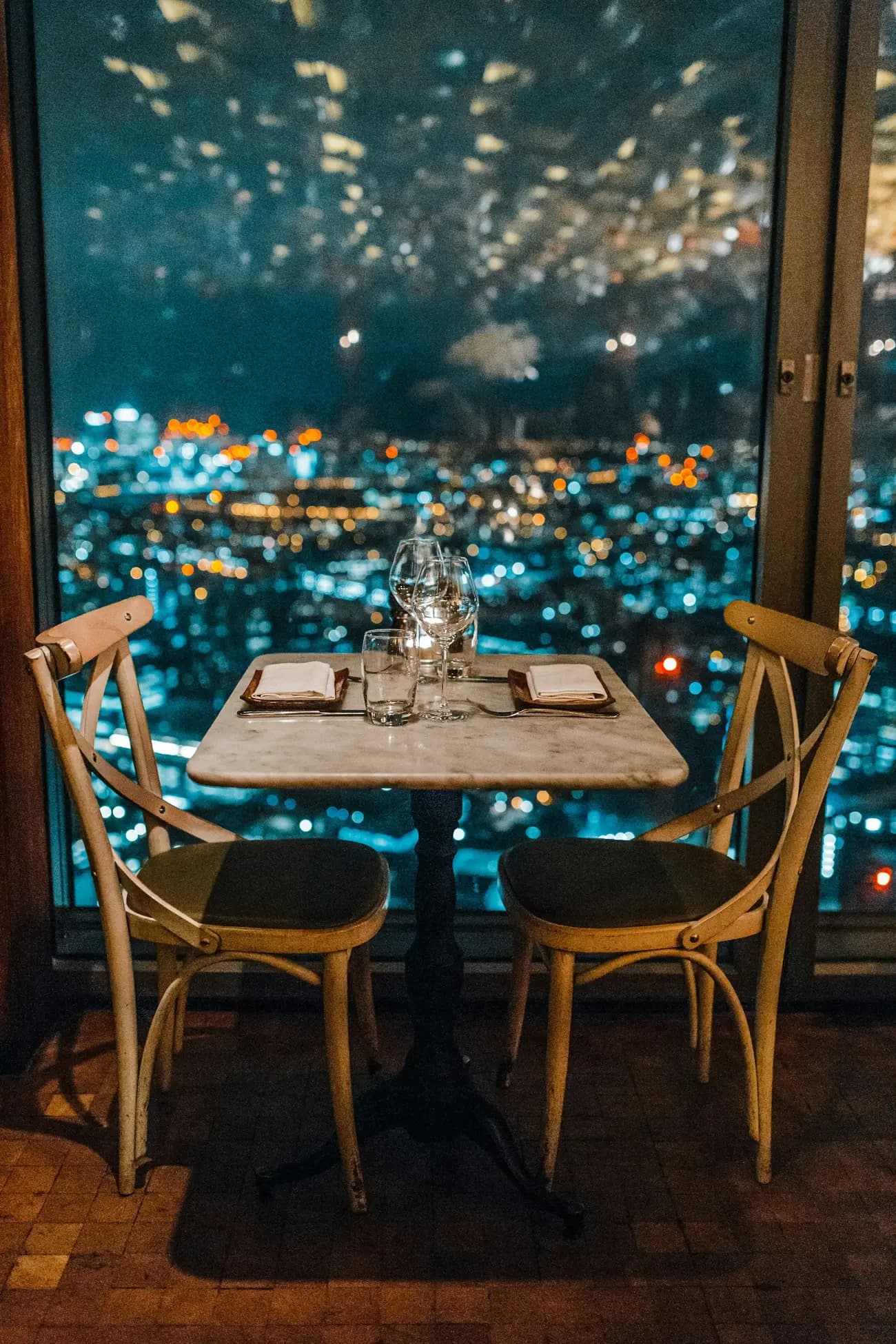 Table for two above city lights at night (illustrative)
