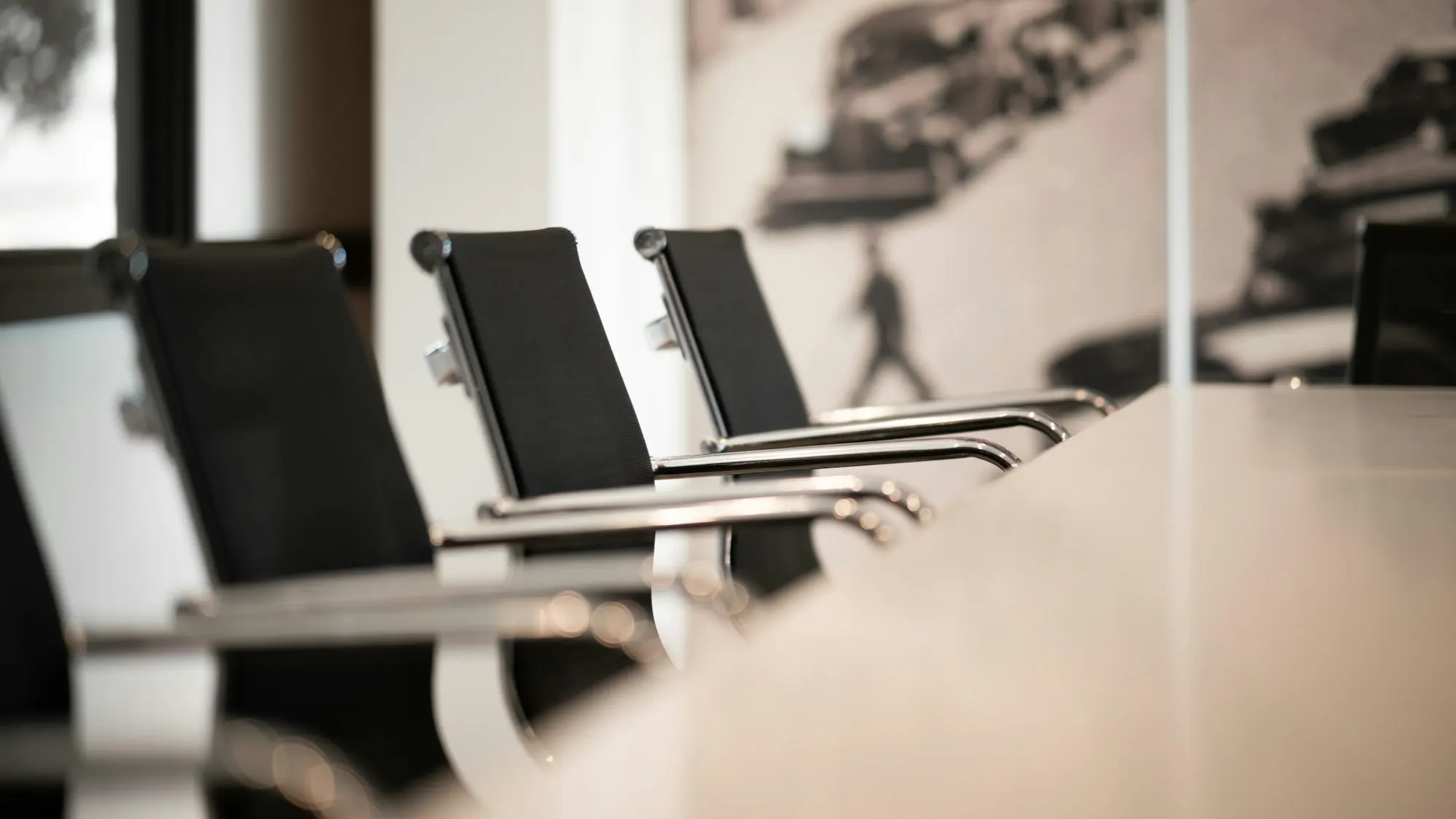 Office chairs lined up at a conference table (illustrative)